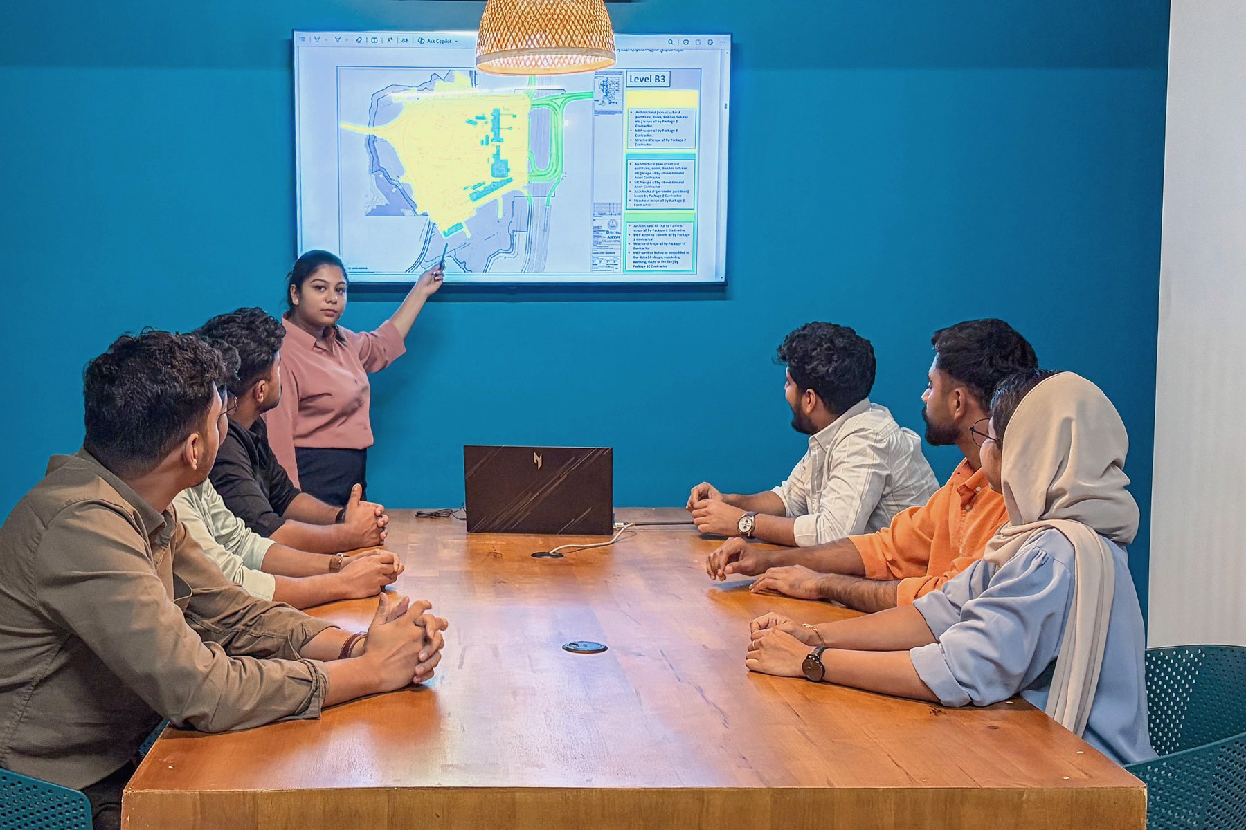 MJ Designs team discussing a project review in the Manjeri meeting room