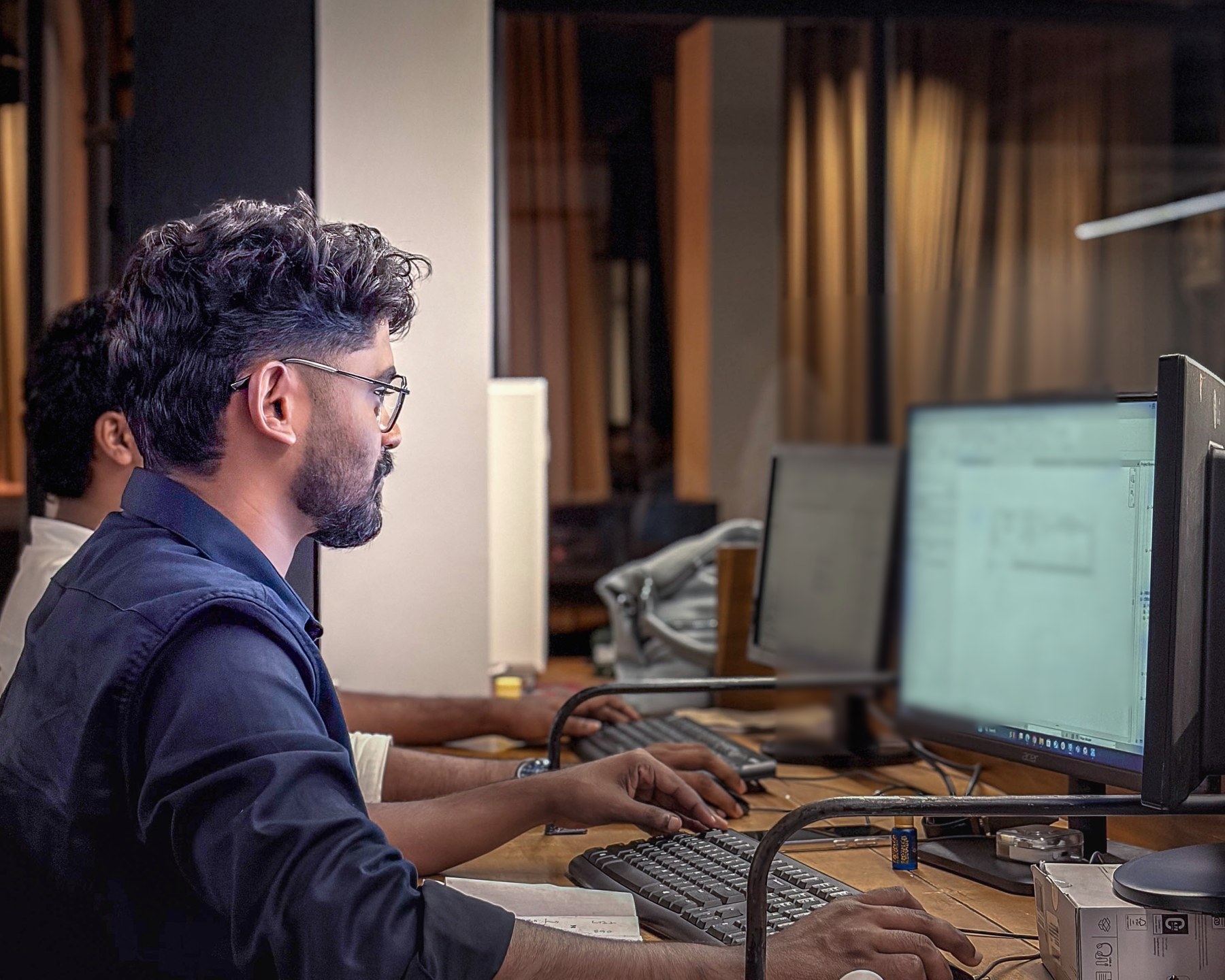MJ Designs BIM specialist reviewing technical model information at a workstation
